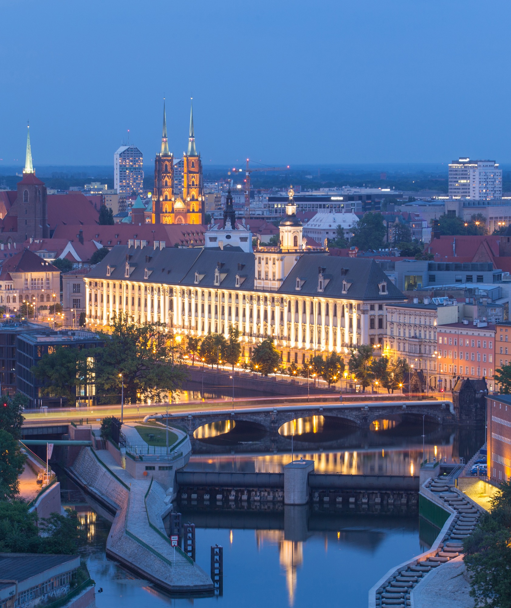 Panorama Wrocławia o zmierzchu z rzeką i oświetlonymi budynkami